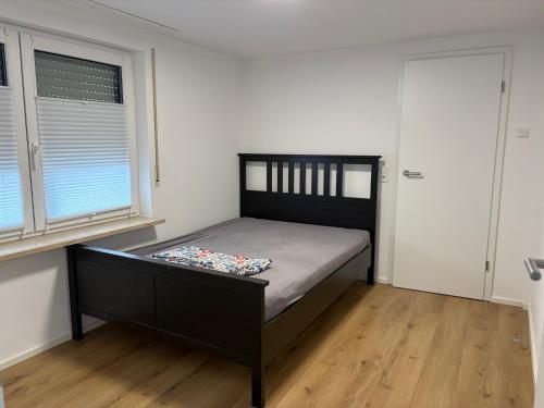 a bedroom with a bed and two windows at VITA Apartment in Herrenberg