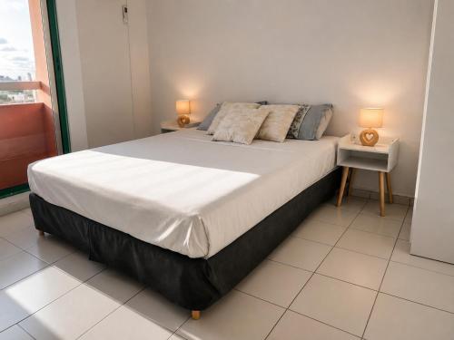 a bedroom with a large bed with two lamps on it at Le Palm Loft in Pointe-à-Pitre