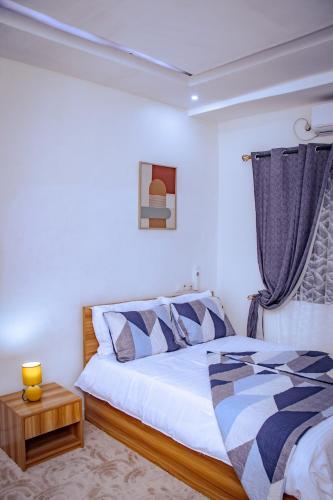 a bedroom with a bed and a table with a lamp at La Cas'a Yehud in Aoudja