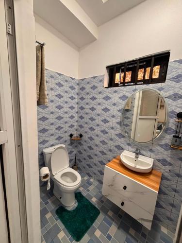 a bathroom with a toilet and a sink and a mirror at La Cas'a Yehud in Aoudja