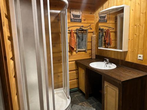 a bathroom with a shower and a sink at Kāpas Wood house in Uguņi