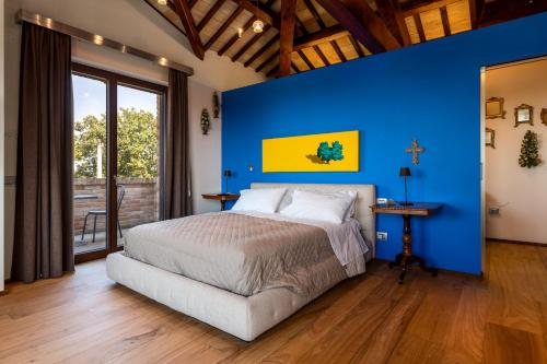a bedroom with a blue wall and a bed at Lucciole e Lavanda BeB in Macerata