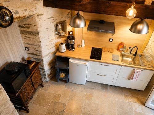 a kitchen with a counter with a sink and a stove at Le Moulin Neuf, logements atypiques dans le Pays d'Ancenis in Anetz