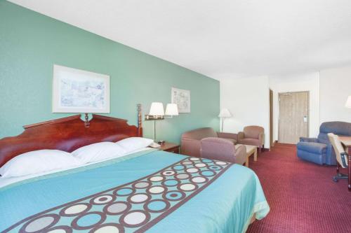 a hotel room with a large bed and a living room at Rockwood Inn Kennett I 55 Near Blytheville in Kennett