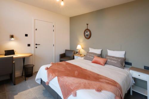 a bedroom with a bed with a desk and a chair at Vakantiewoning Maison Chaperon in Wervik