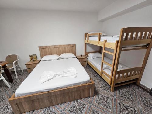 a room with two bunk beds and a table at Daja's Guest House in Shëngjin