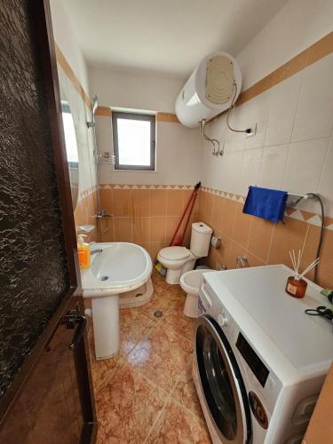 a bathroom with a toilet and a washing machine at Daja's Guest House in Shëngjin