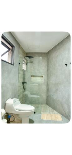 a bathroom with a white toilet and a sink at Torre meridt in Santo Domingo