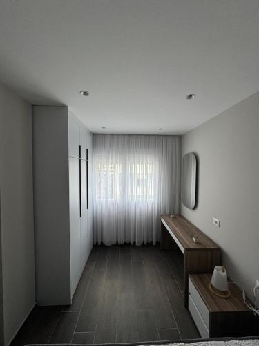 a room with a bench and a mirror and a window at Sandy Vibes Apartments in Durrës