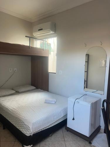 a bedroom with a large bed with a dresser and a mirror at Hotel Pará Santarém PA in Santarém