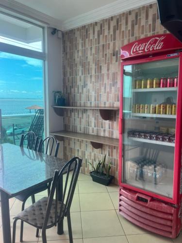 a cocacola refrigerator in a dining room with a table at Hotel Pará Santarém PA in Santarém