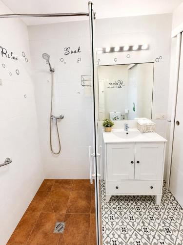 a bathroom with a shower with a sink and a mirror at Casa Juana in Facinas