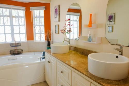 a bathroom with a large tub and a sink and a tubermott at Cap Estate Ocean View Villa, Gros Islet, St Lucia in Dame de Traversay