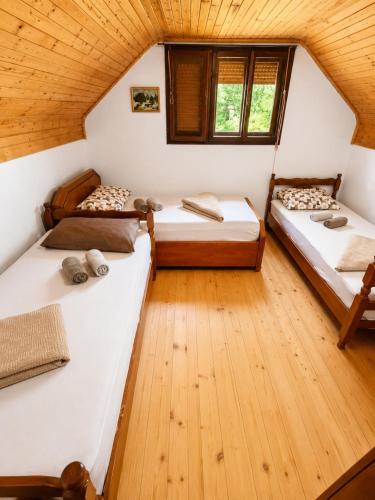 two beds in a room with wooden floors at Srce Prirode in Pljevlja