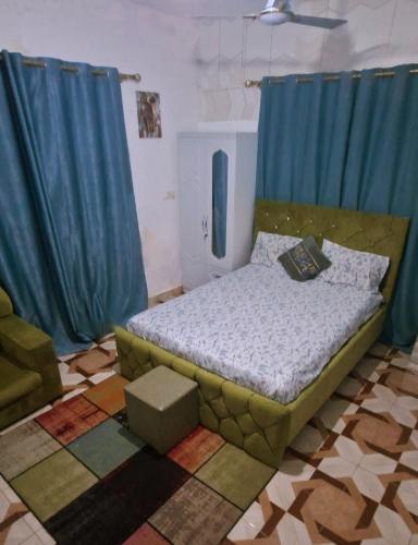 a bedroom with a bed with blue drapes at Master Home in Baatsona