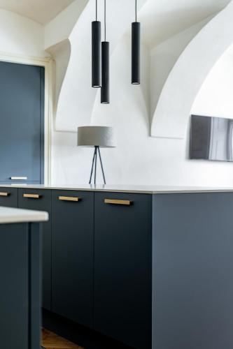 a kitchen with black cabinets and black counters at Main Square Apartments in Maribor