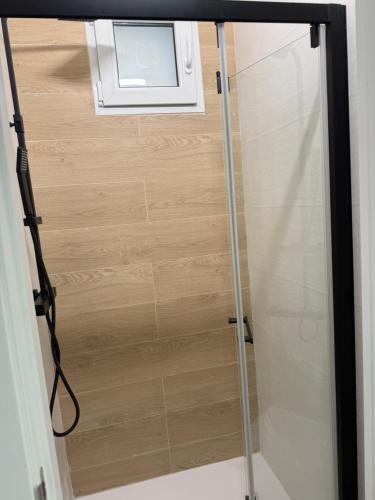 a glass shower door with a window in a bathroom at La Barraca in Gandía