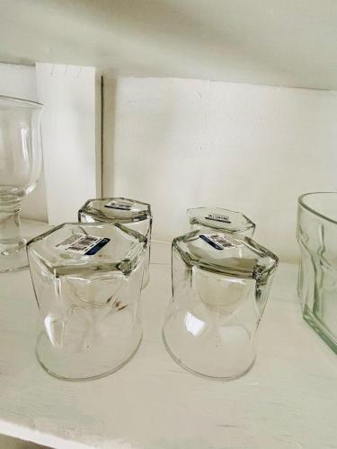 three clear glasses sitting on top of a shelf at Casa en grupo, terraza y alberca compartida in Mexicali