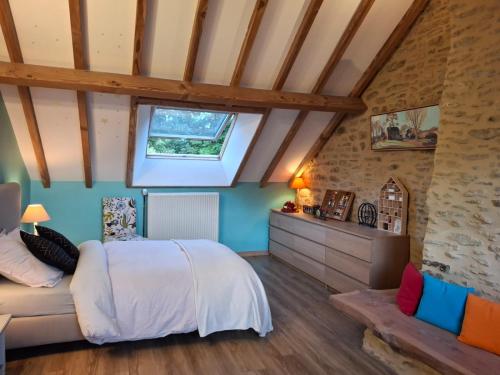 a bedroom with a bed and a window at Au Lou Pélélée in Madranges