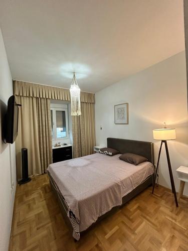 a bedroom with a bed and a television in it at Jednosoban stan Tivat in Tivat