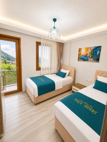 a hotel room with two beds and a window at Auga Apart in Uzungöl