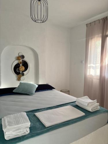 a bedroom with a bed with towels on it at 7Olives Azure Boutique Apartment in Kastraki