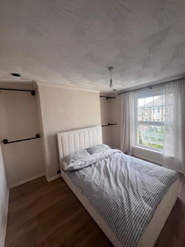 a white bedroom with a bed and a window at Gravesend Central - Spacious & Quiet Rooms in Gravesend