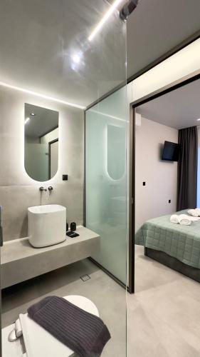 a bathroom with a sink and a bed at Ammos Maisonettes in Pefkari