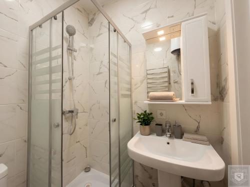 a white bathroom with a sink and a shower at RentHouse Apartments-Old Town Studio #2 in Chişinău