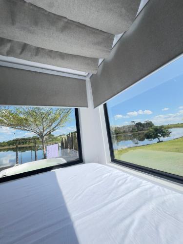 a bedroom with a bed and a large window at Refúgio do Lago in Linhares