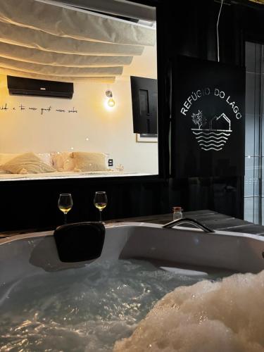a bath tub with two wine glasses in it at Refúgio do Lago in Linhares