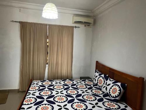 a bedroom with a bed with a black and white comforter at The Senegambia Hideaway in Amdalai
