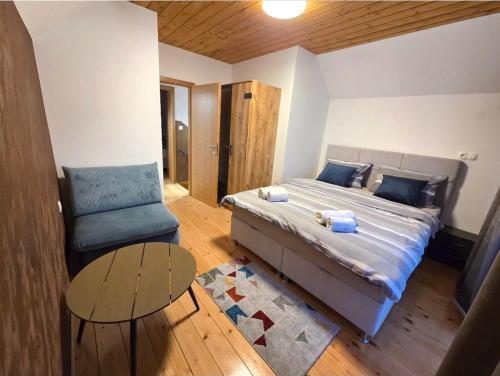 a bedroom with a bed and a chair and a table at Petar in Kamešnica