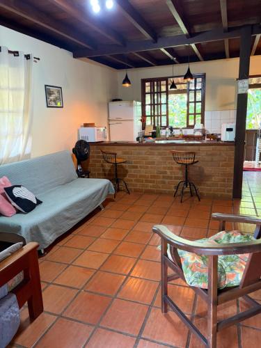 a living room with a bed and a kitchen at Chalé Lumiar M&C in Lumiar