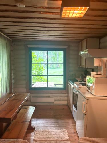 a kitchen with a large window in a room at Löydön Kartano Camping in Mikkeli