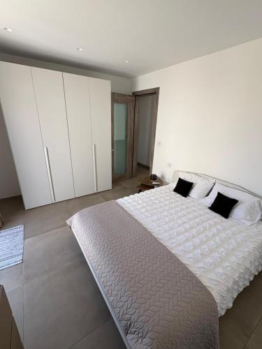 a bedroom with a large bed and white cabinets at Cute little Penthouse in the Heart of Sliema in Sliema