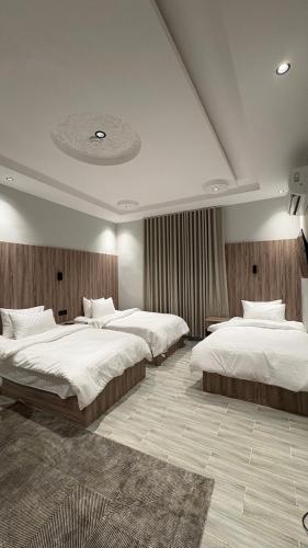 a bedroom with three beds in a room at Qubaa Soul Studio 2-3 in Medina