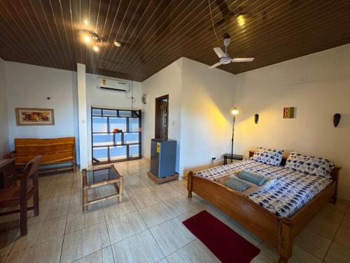 a bedroom with a bed and a table and a chair at Sunflower Beach Resort in Senya Beraku