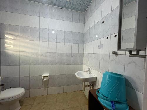 a bathroom with a toilet and a sink at Sunflower Beach Resort in Senya Beraku