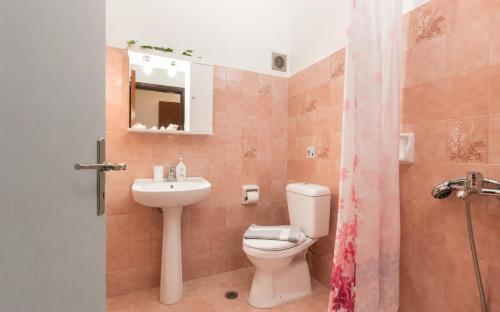 a bathroom with a toilet and a sink at Gennadi Sun Apartments 500m from the beach in Gennadi