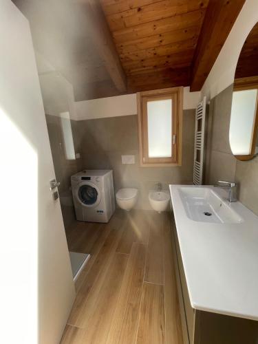 a bathroom with a toilet and a sink and a microwave at Vacanze in centro a un passo dal mare in Montesilvano