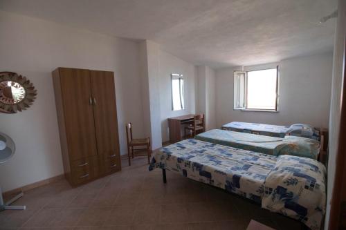 a bedroom with a bed and a dresser at Fondaco del Capo in Capo Vaticano