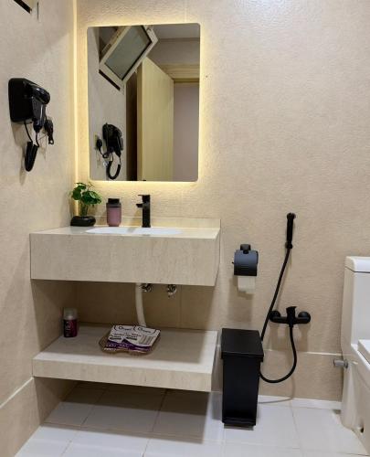 a bathroom with a sink and a mirror at لينك هوم استديو فندقي دخول ذاتي in Buraydah