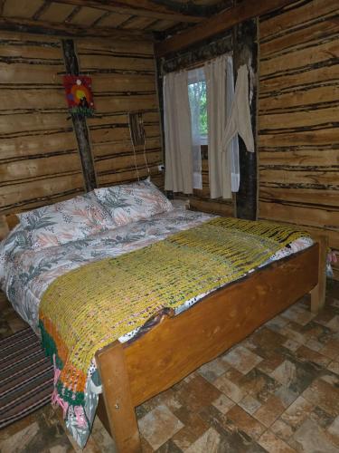 a bedroom with a bed in a log cabin at Refugio de la Montaña 2 personas in Coñaripe