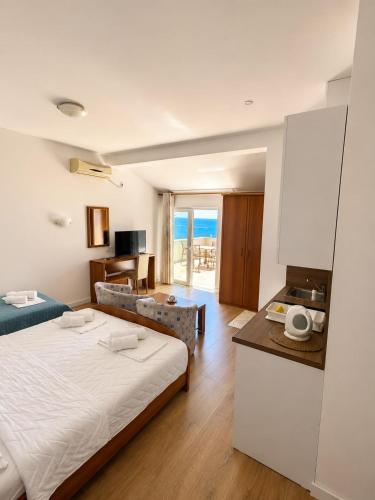 a bedroom with a large bed and a living room at Apartments Hollaj in Ulcinj