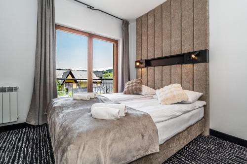 two beds in a room with a large window at Home Tatra in Biały Dunajec