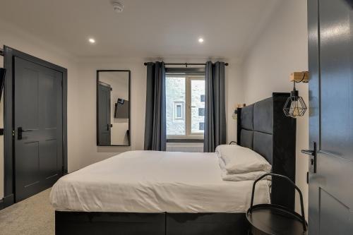 a bedroom with a large bed and a mirror at The Righ in Oban