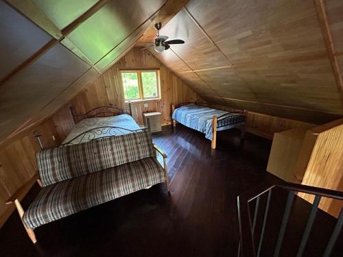 an attic with two beds and a couch in a room at Chalet de toutes saisons in Shawinigan