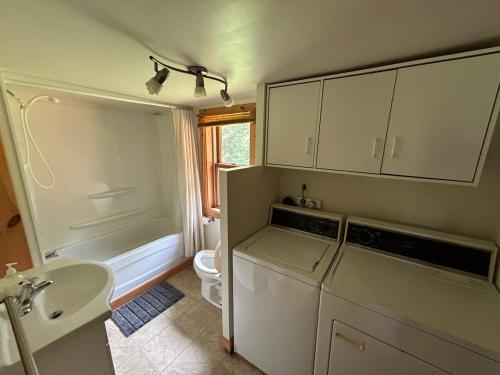 a kitchen with a refrigerator and a toilet and a sink at Chalet de toutes saisons in Shawinigan