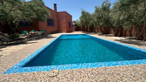 a swimming pool in front of a house at Tissi House in Tahannout